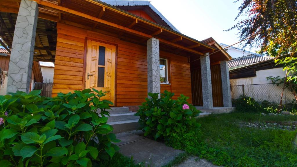 une petite maison en bois avec une porte jaune dans l'établissement садиба Пан Коцький, à Kossiv