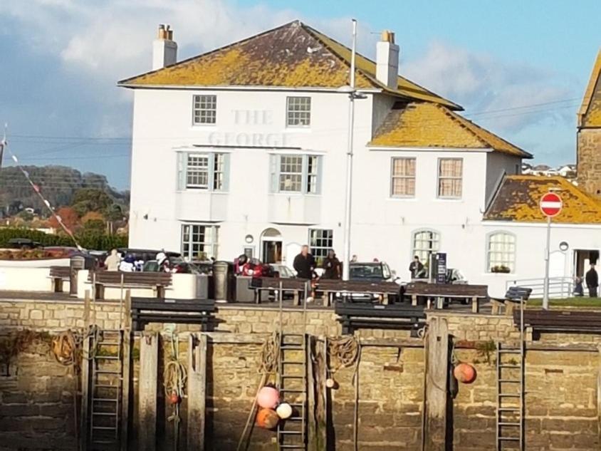 a large white building with a fence in front of it at The George in West Bay