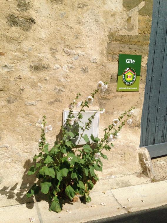 une installation sur le côté d'un bâtiment avec un panneau dans l'établissement Gites les Tournesols, à Auvers-sur-Oise