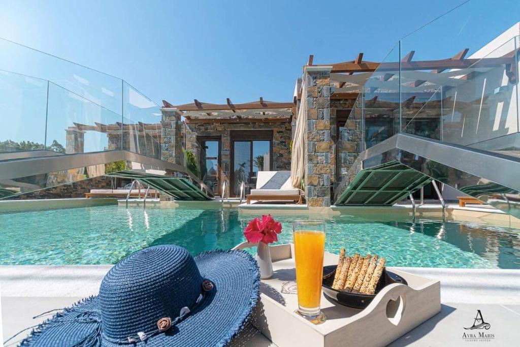 um chapéu azul e uma bebida junto a uma piscina em Avra Maris em Sitia