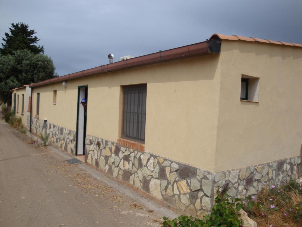 un bâtiment avec un mur en pierre à côté d'une rue dans l'établissement Piccola Dependance, à Syracuse