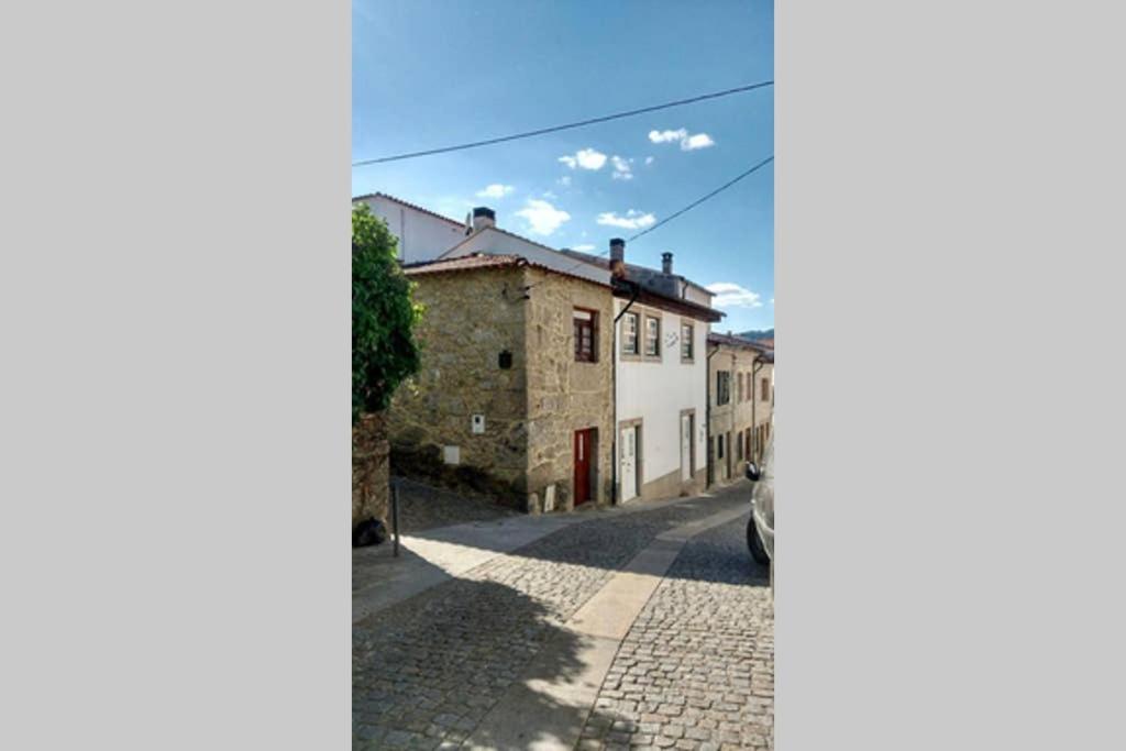 a street with houses and a car parked on the street at Casa da Mininha in Ponte da Barca