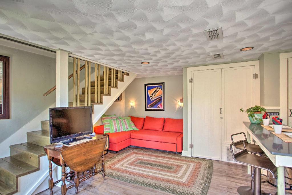sala de estar con sofá rojo y escalera en The Quarters at Fairmount Cottage with Shared Pool en Fort Worth