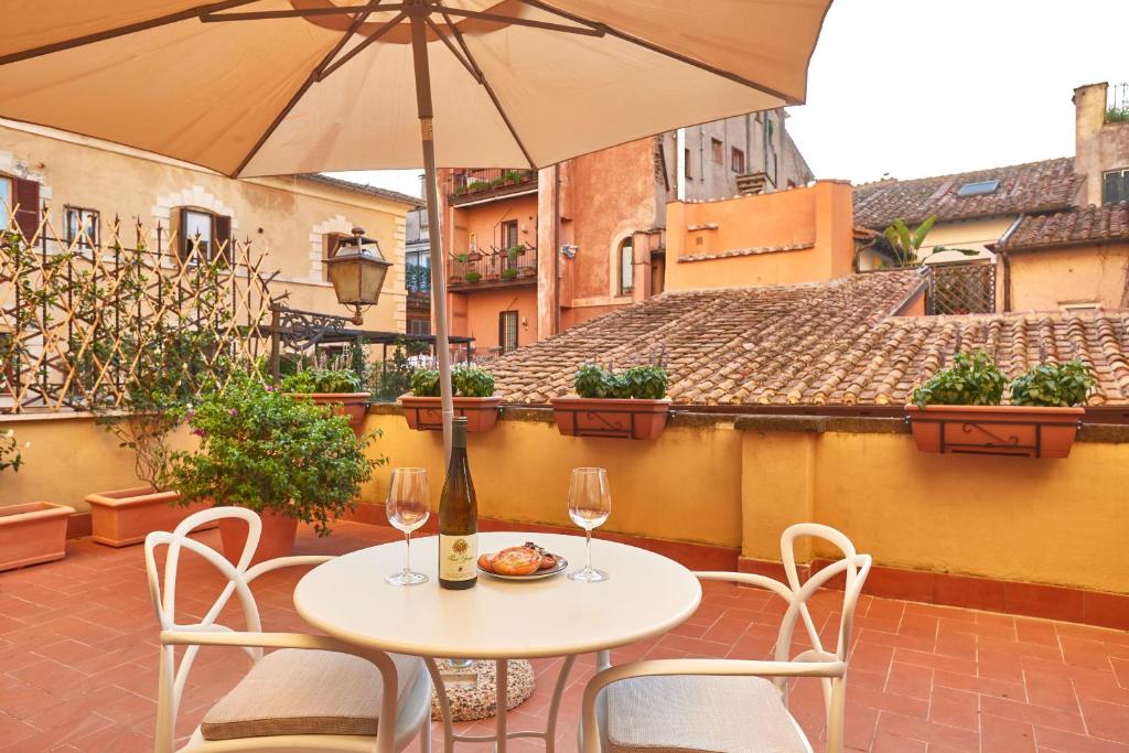 d'une table et de chaises sur un balcon avec un parasol dans l'établissement Ripagrande a Trastevere, à Rome