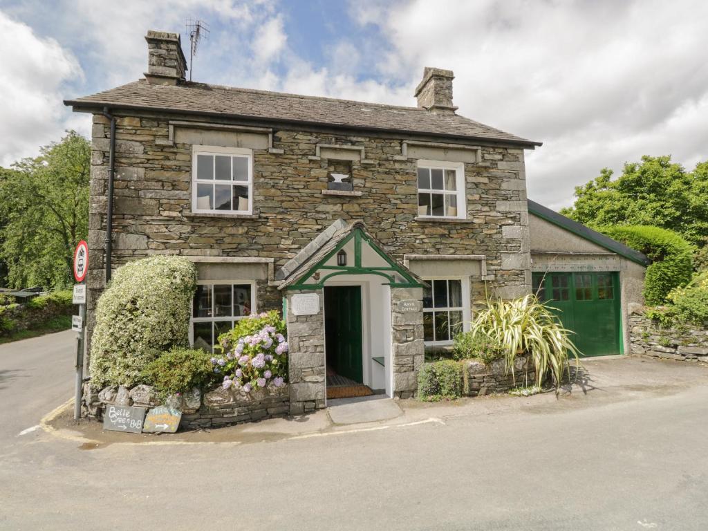 an old stone house with a green door at Anvil Cottage in Near Sawrey
