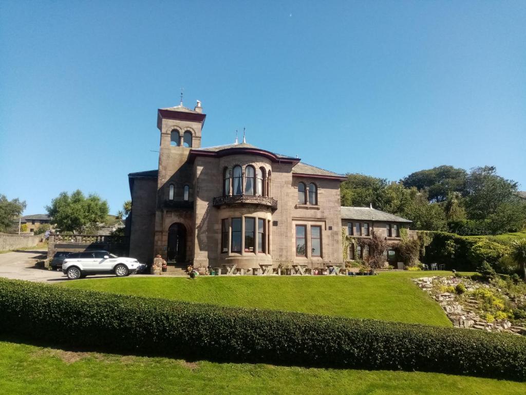 a house with a car parked in front of it at Craigard House Hotel in Campbeltown