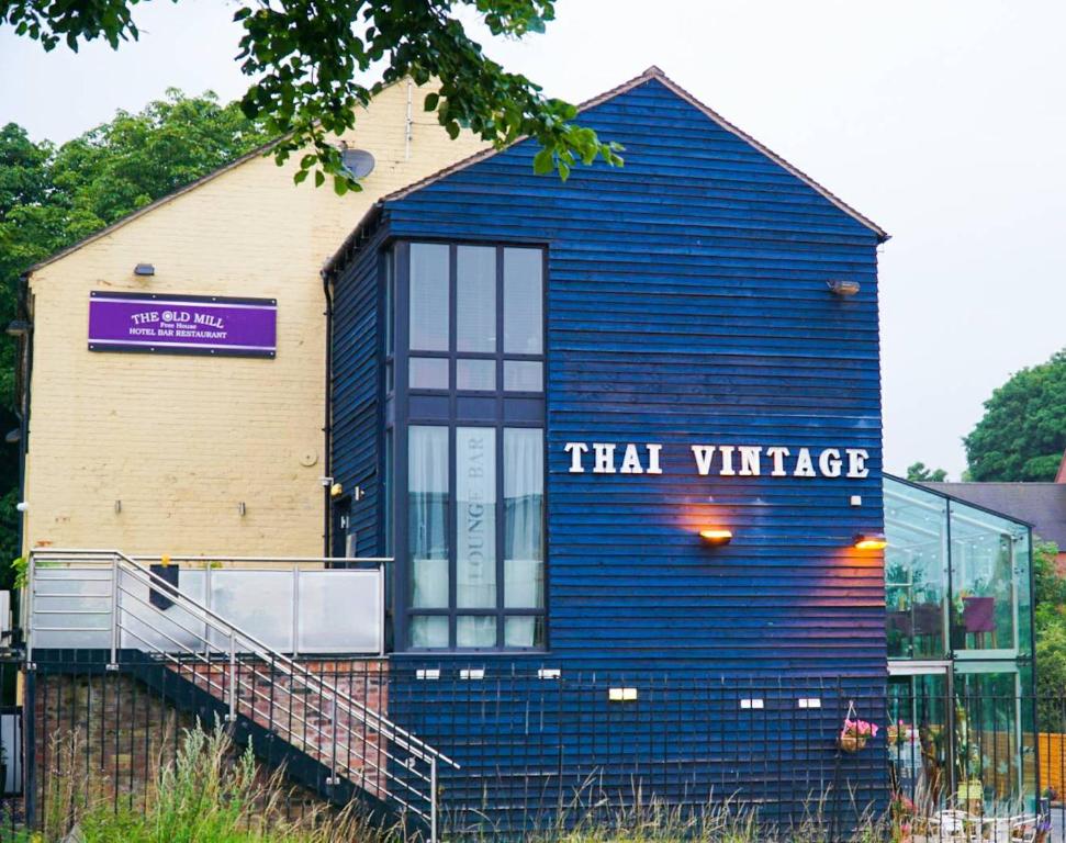 a blue building with a sign that reads trail village at The Old Mill Thai vintage in Whitchurch