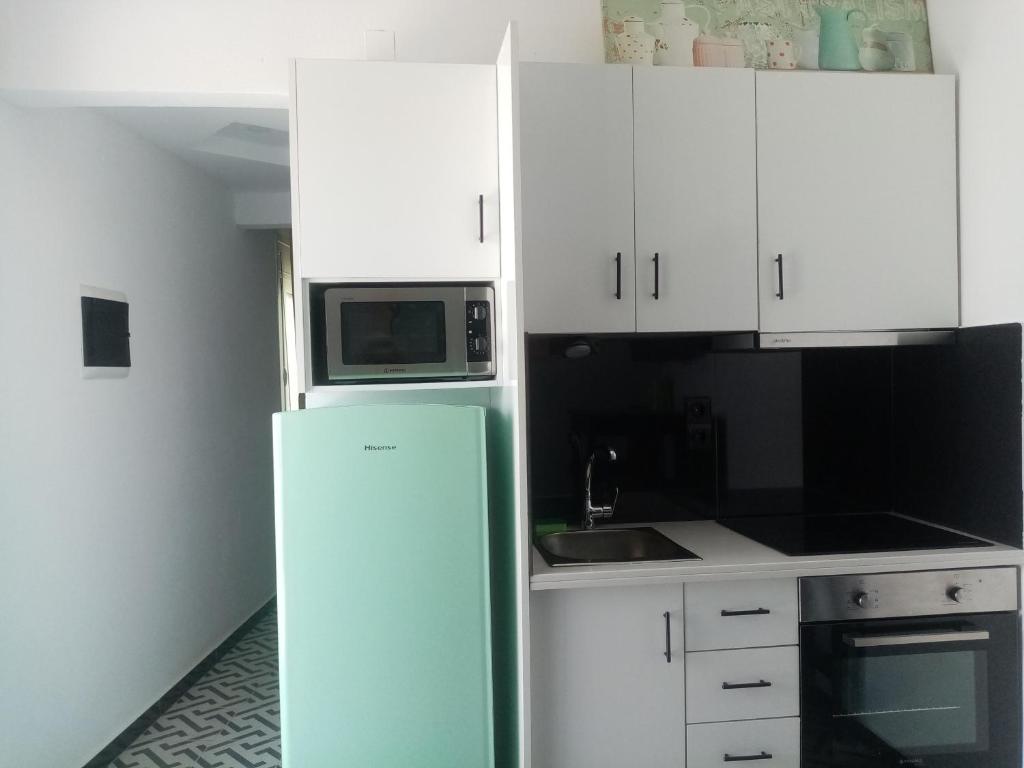 a kitchen with a refrigerator and a microwave at Maria's Doll House in Adelianos Kampos