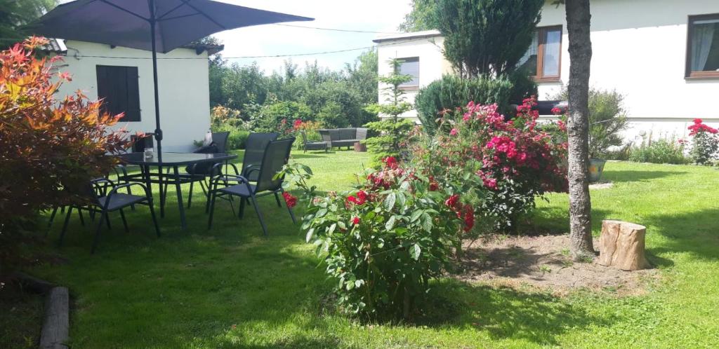 ogród ze stołem, krzesłami i kwiatami w obiekcie Domek na wsi. w Kazimierzu Dolnym
