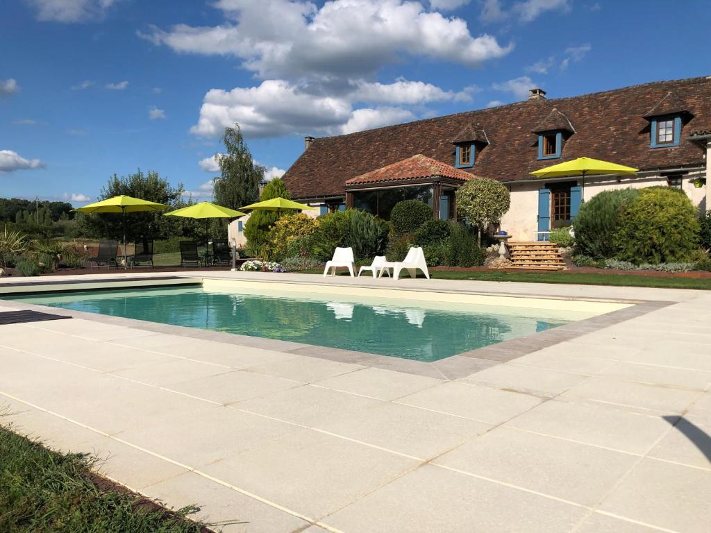 uma piscina em frente a uma casa com cadeiras e guarda-sóis em DCV Summer Home em Blis-et-Born