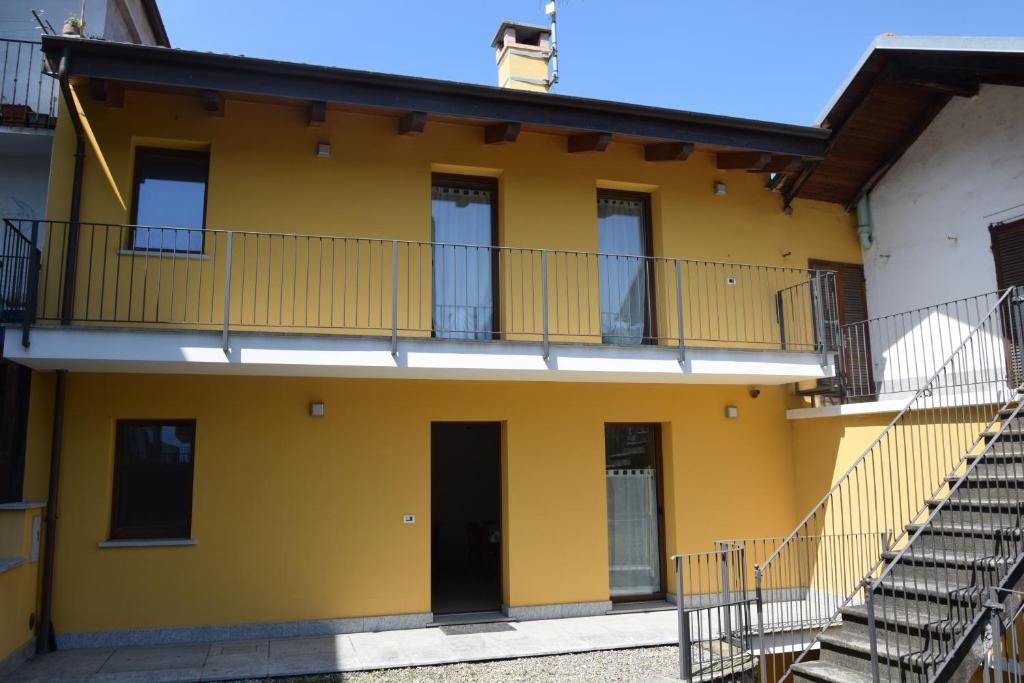 a yellow building with a staircase in front of it at Casa Vecchia, ma Moderna in Villar Perosa