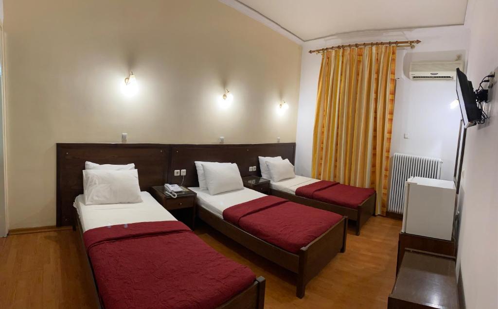 a hotel room with two beds and a tv at Ξενοδοχείο Acropol in Larisa