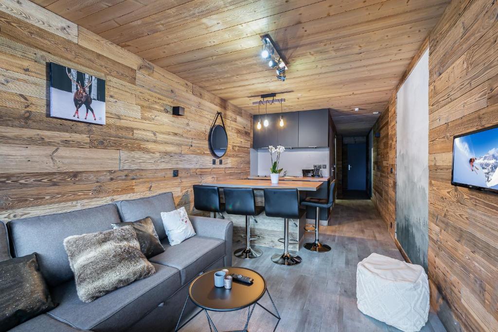 een woonkamer met een bank en een tafel bij Appartement de charme hyper centre à Val d'Isère in Val dʼIsère