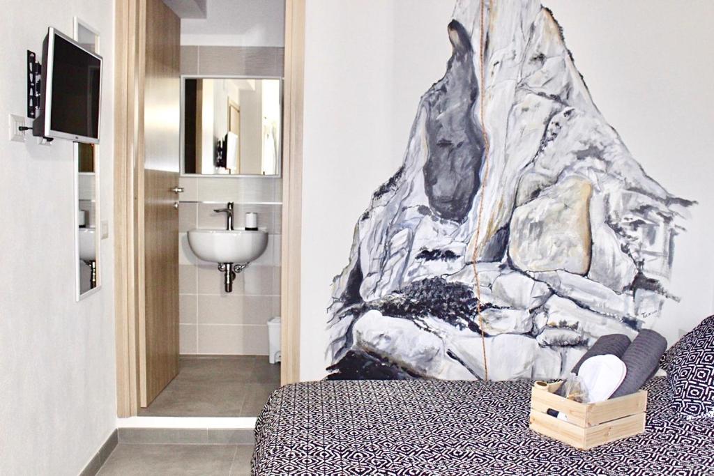 a bedroom with a wall mural of a mountain at bedandclimbing in Baunei