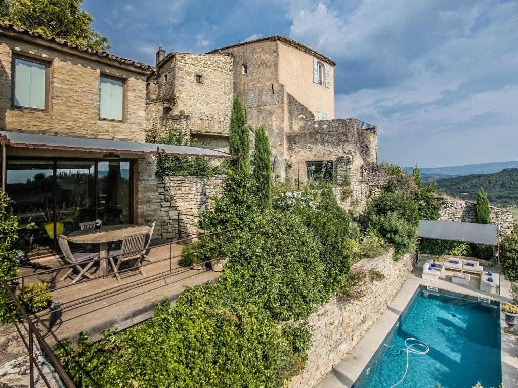 a villa with a swimming pool and a house at Villa Sunset in Gordes in Gordes