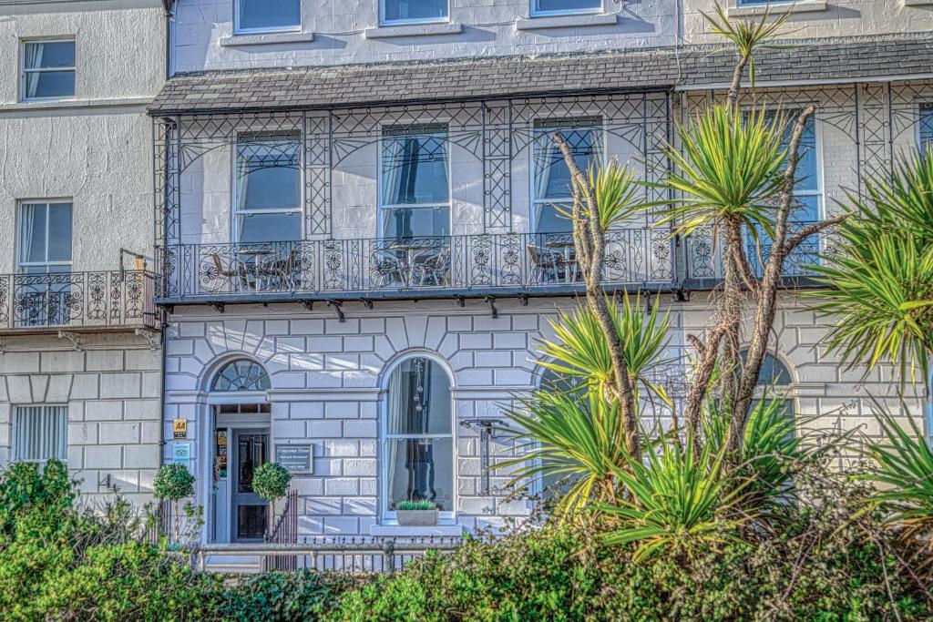 um edifício com varanda e palmeiras em Gloucester House em Weymouth