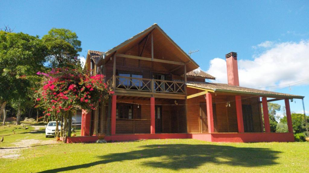 a large house with a grass yard in front of it at Chacara da Dinda in Piraquara