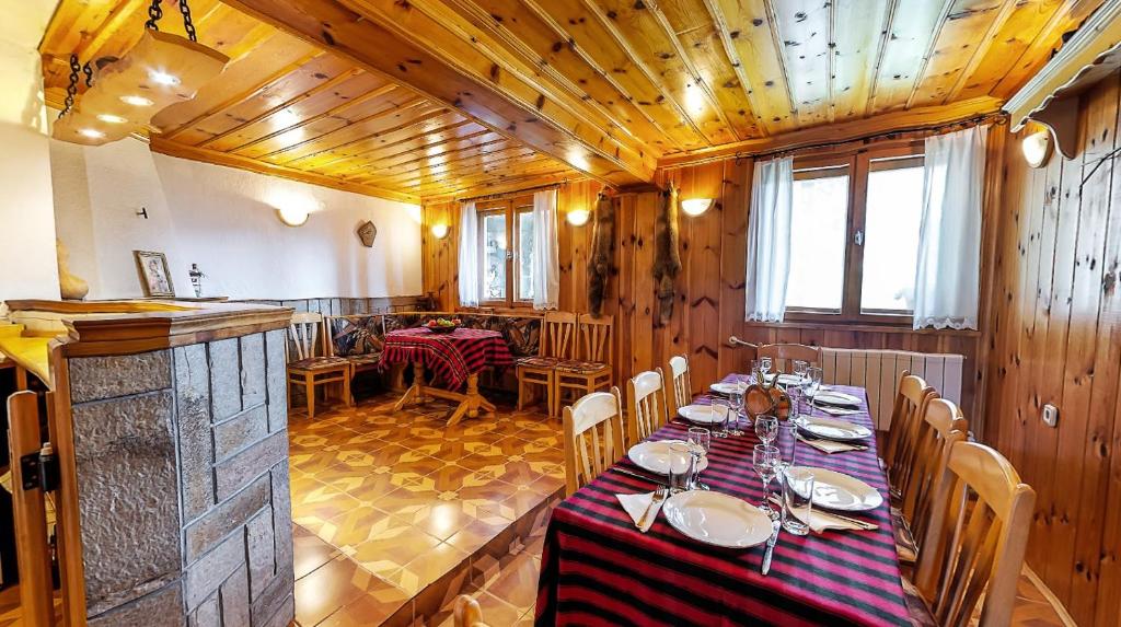 a dining room with a long table and chairs at Къща за гости Каневи in Momchilovtsi