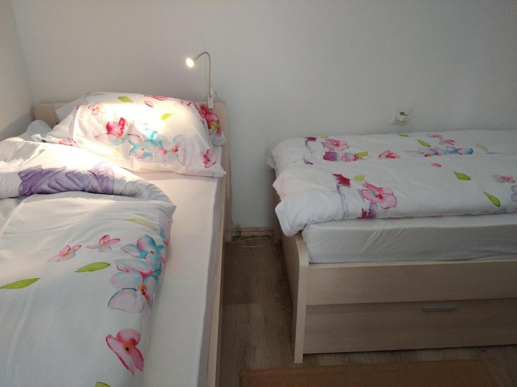 a bedroom with two beds with flowers on the sheets at Botanical garden in Zagreb