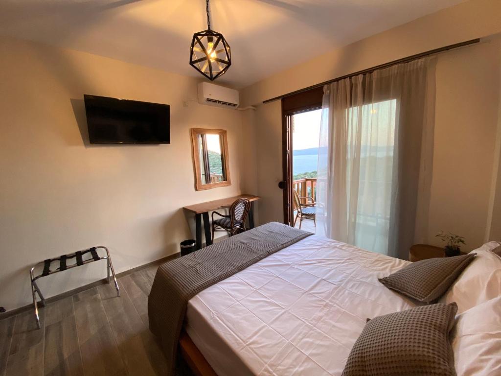 a bedroom with a bed and a tv and a window at Escape at Ammouliani in Ammouliani