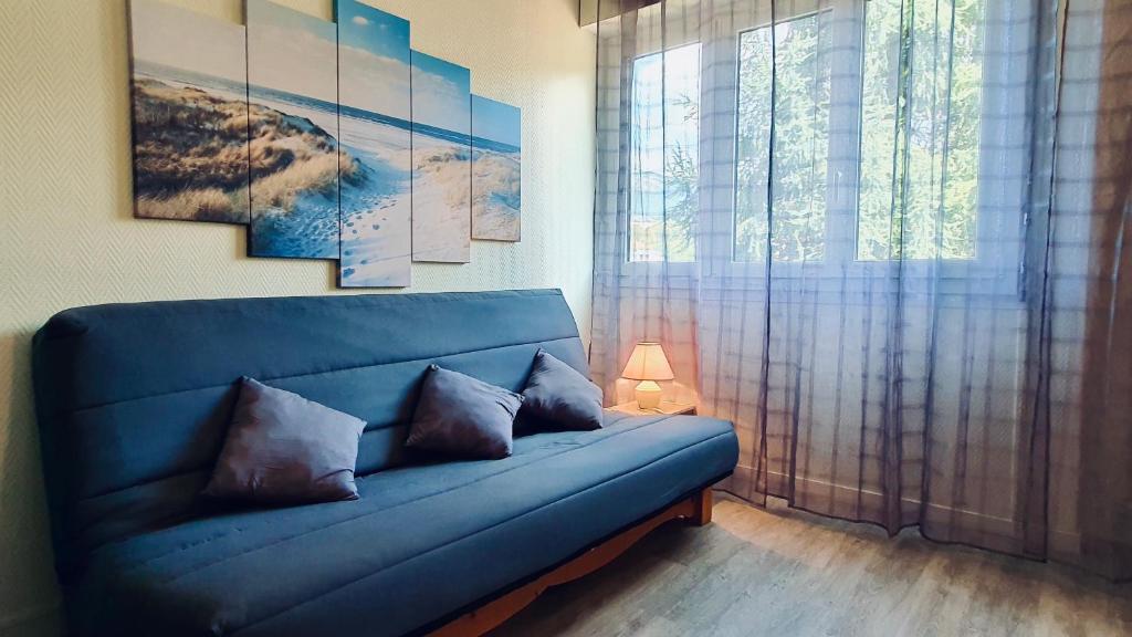 - un canapé bleu dans le salon doté d'une fenêtre dans l'établissement Annecy : #Studio #Mont Veyrier #Semnoz #Visitation, à Annecy