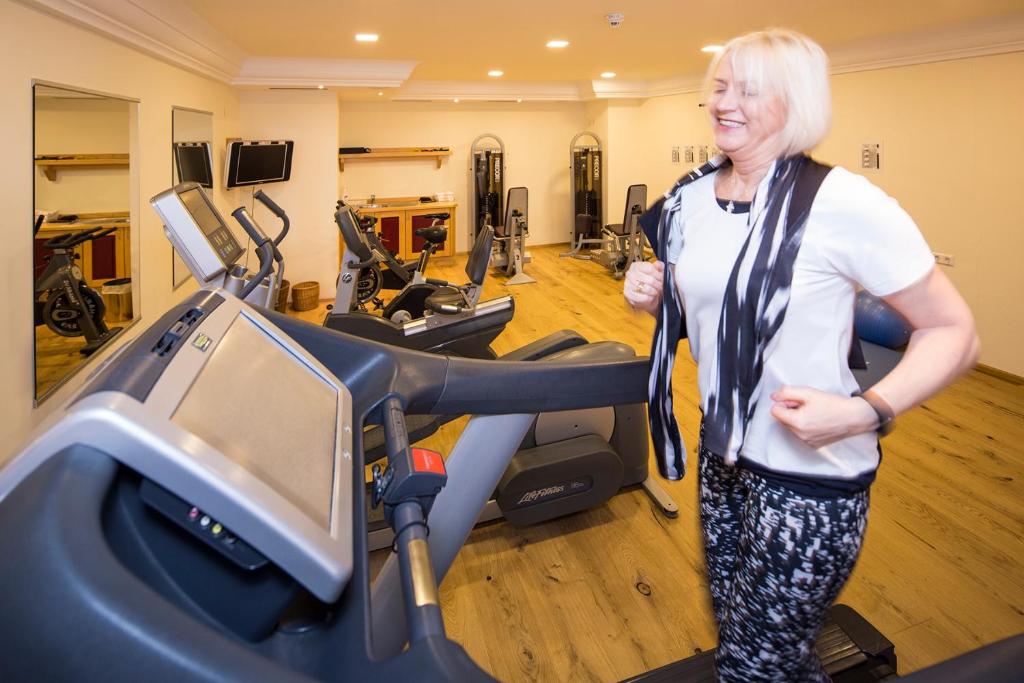 a woman standing in a gym on a treadmill at Hotel Zum Schwarzen Bären in Emmersdorf an der Donau