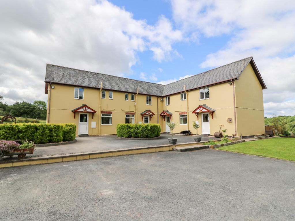 a large yellow building with a driveway at Red Kite Cottage in Llandrindod Wells