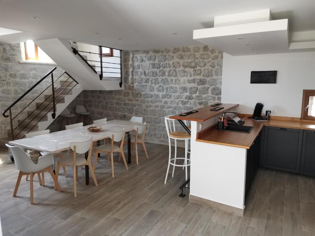 a kitchen and dining room with a table and chairs at Maison du Troubadour in Balazuc