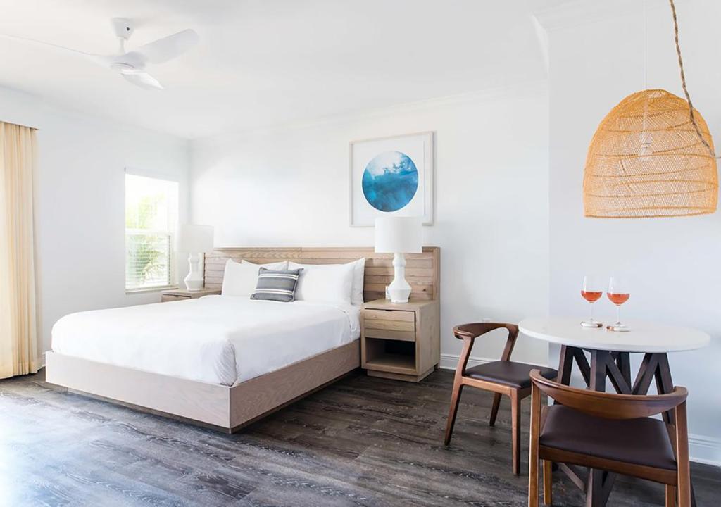 ein Schlafzimmer mit einem Bett und einem Tisch und Stühlen in der Unterkunft Parrot Key Hotel &amp; Villas in Key West