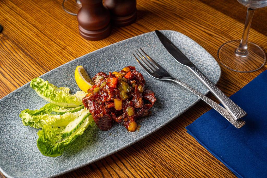 a plate of food with lettuce and meat with a lemon at The Bold Hotel; BW Signature Collection in Southport