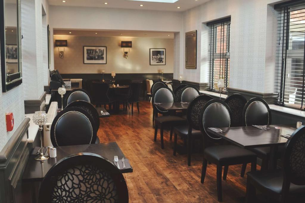 a restaurant with black chairs and tables and a room with tables at The Eccleston Hotel; BW Signature Collection in Saint Helens