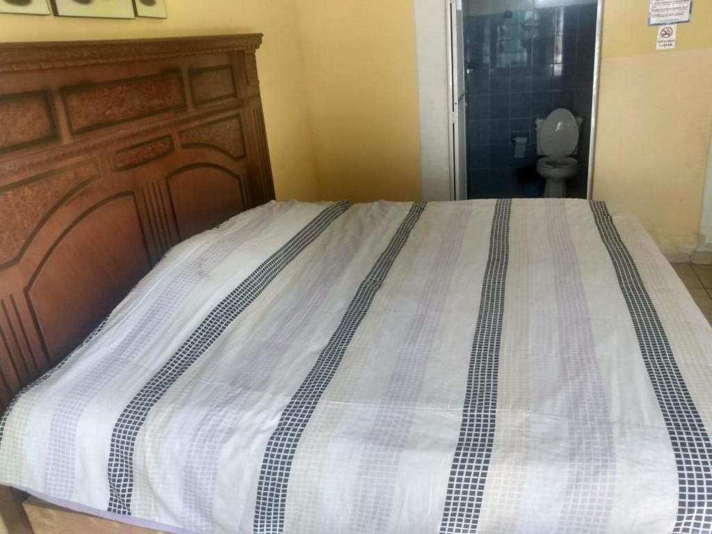 Villas Yoleth Hotel في شاشالاكاس: غرفة نوم مع سرير مع اللوح الأمامي الخشبي