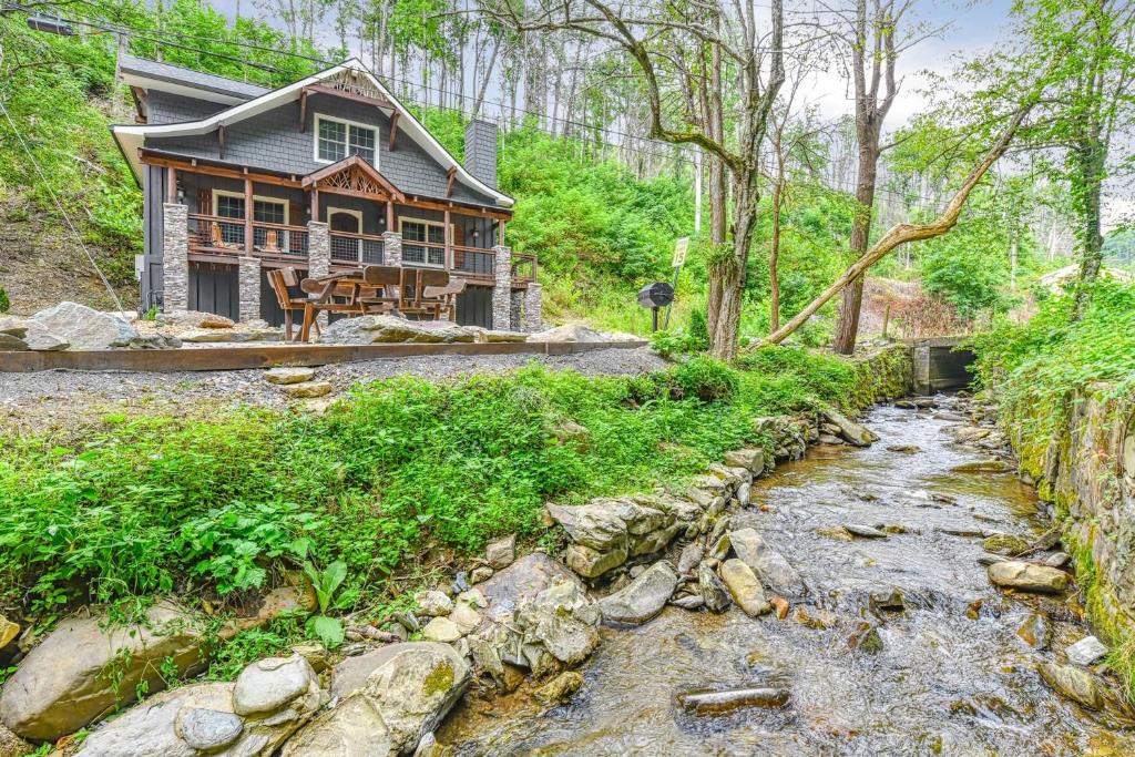 a home with a creek in front of a house at Noir Pine Creekside Chalet in Gatlinburg