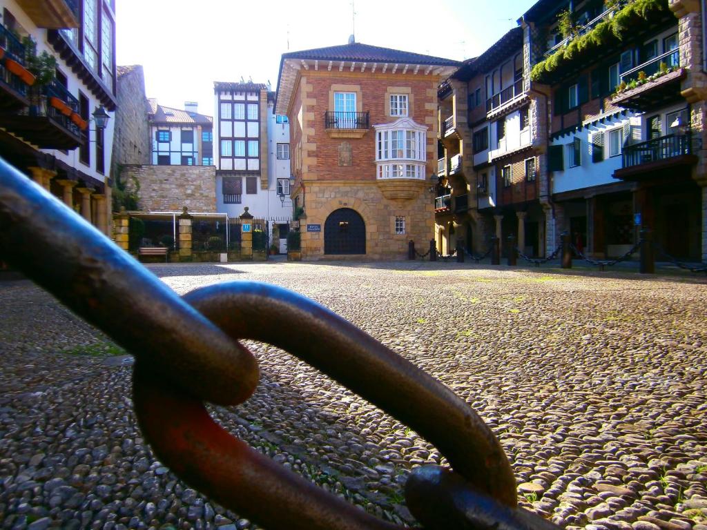 a large metal chain on a street with buildings at Hotel Palacete in Hondarribia