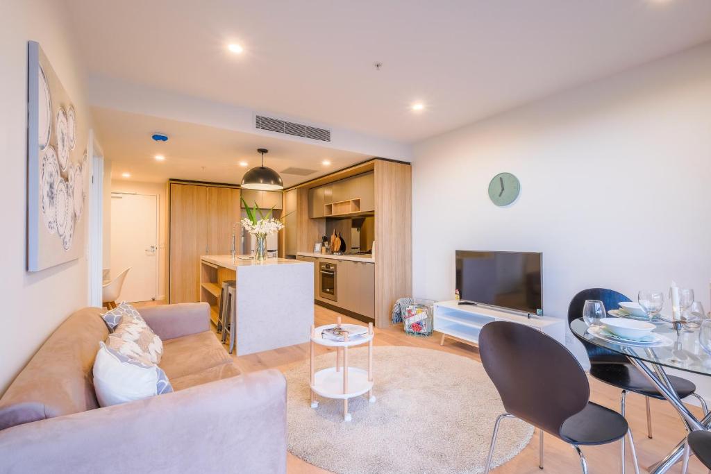 a living room with a couch and a tv at AirTrip Apartments at Woolloongabba in Brisbane