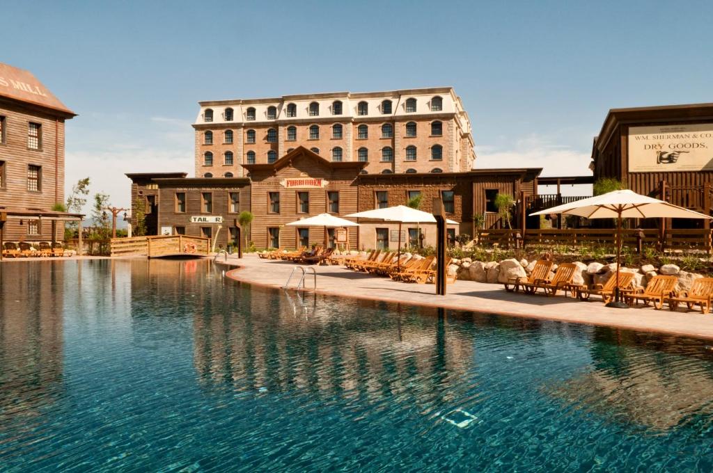 una piscina de hotel con un gran edificio en el fondo en PortAventura Hotel Gold River - Includes PortAventura Park Tickets en Salou