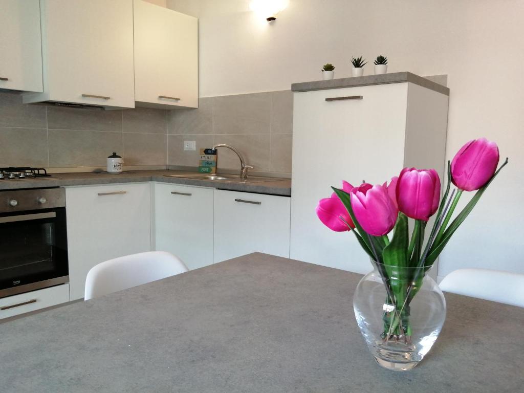 a vase of pink tulips sitting on a kitchen table at Apartment Annive in Levico Terme