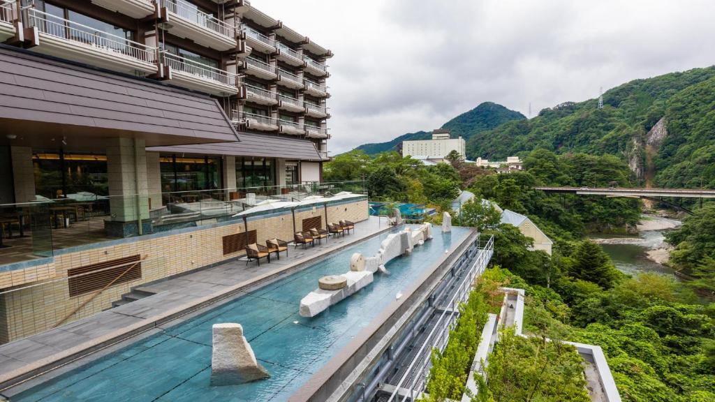 a hotel with a swimming pool next to a river at Kinugawa Hotel Mikazuki in Nikko