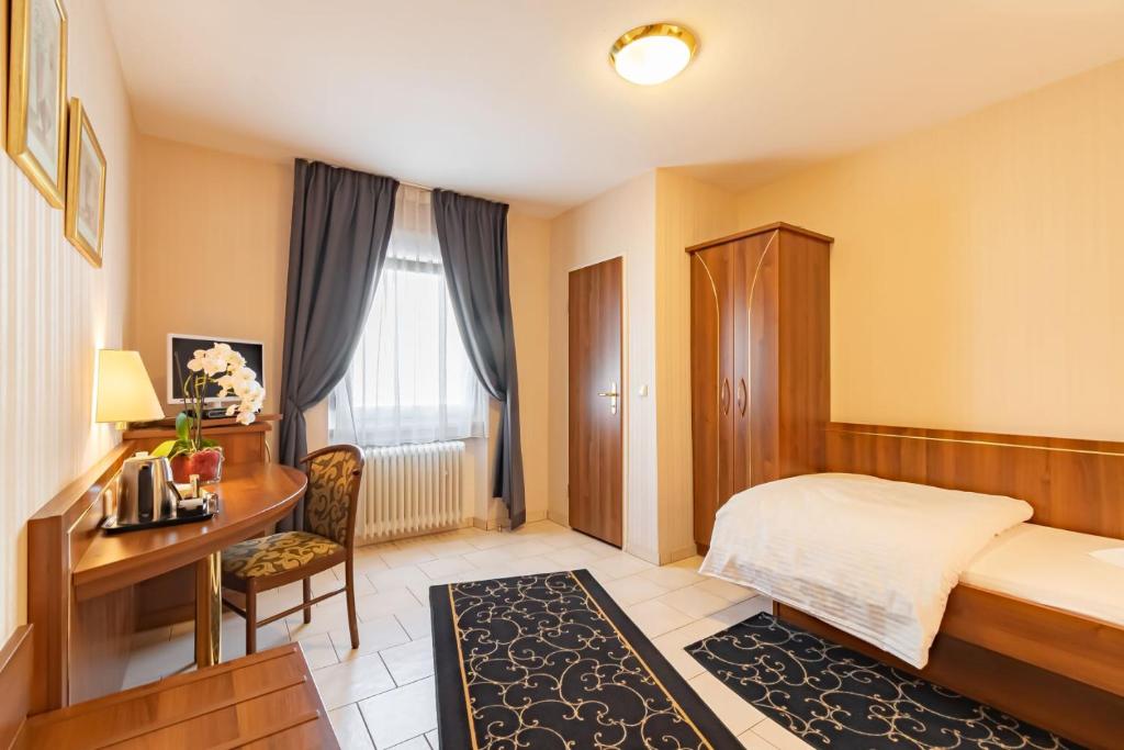 a hotel room with a bed and a desk and a desk at Hotel Re'ser Stuff in Roeser