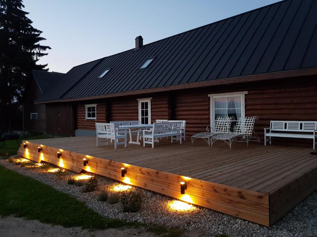 a wooden deck with a table and chairs and lights at Koka Pässä küla Võru vald in Võru