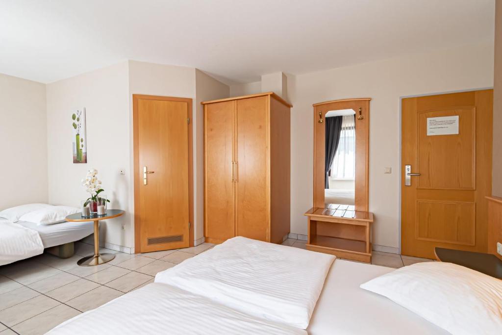 a bedroom with two beds and wooden cabinets at Hotel Re'ser Stuff in Roeser