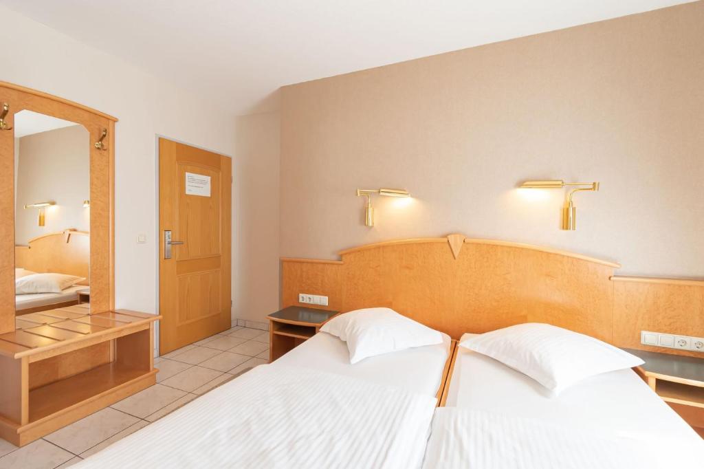 a hotel room with a bed and a mirror at Hotel Re'ser Stuff in Roeser