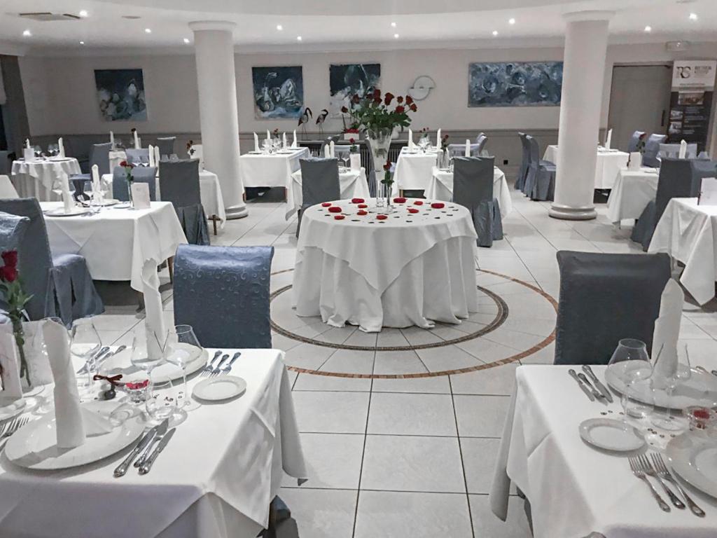 a dining room with white tables and chairs at Hotel Re'ser Stuff in Roeser