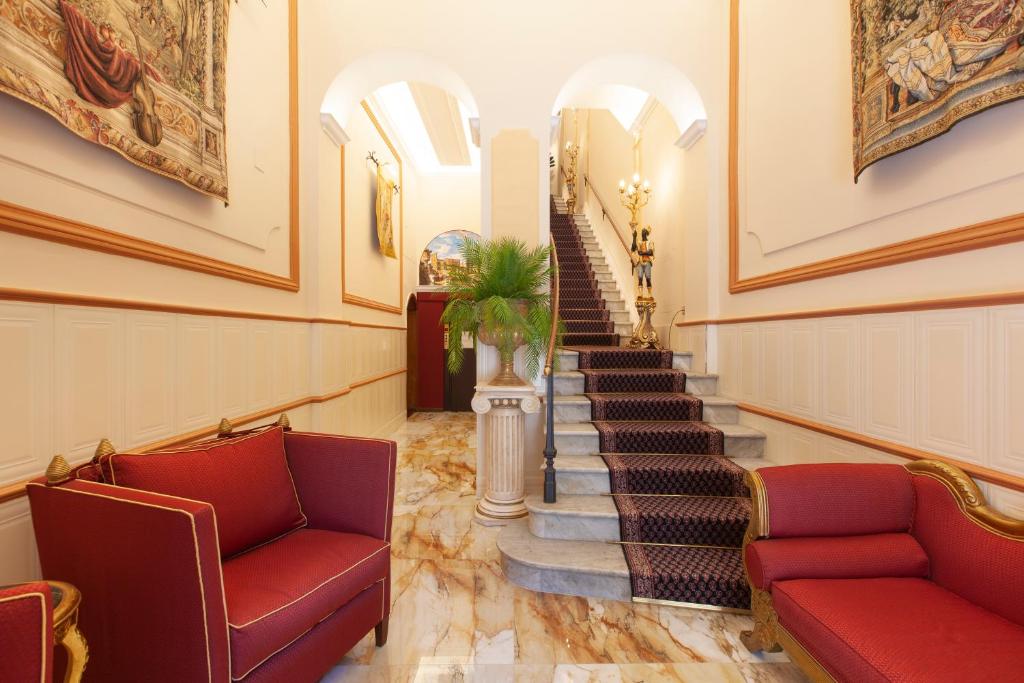 a hallway with red chairs and stairs in a building at Residenza Antica Roma in Rome