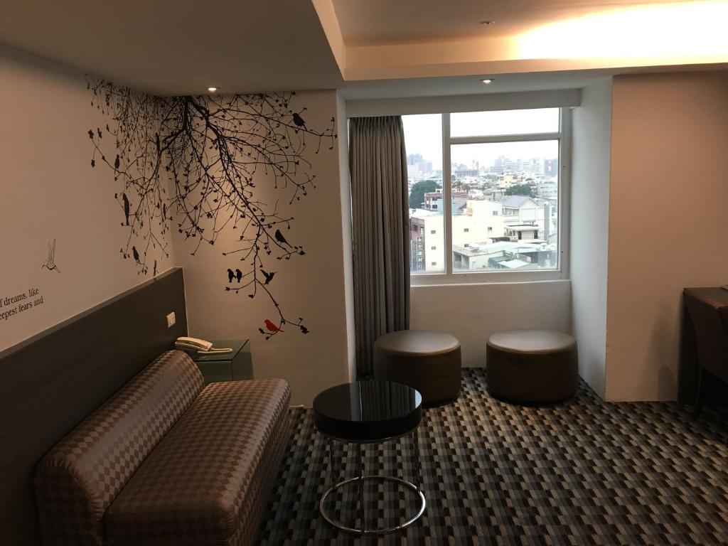 a hotel room with a couch and a window at Chiayi Look Hotel in Chiayi City