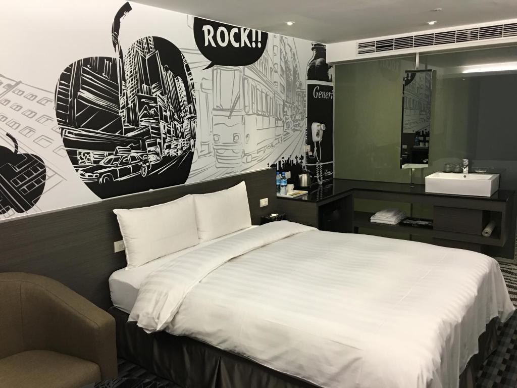 a bedroom with a bed and a bathroom with a sink at Chiayi Look Hotel in Chiayi City