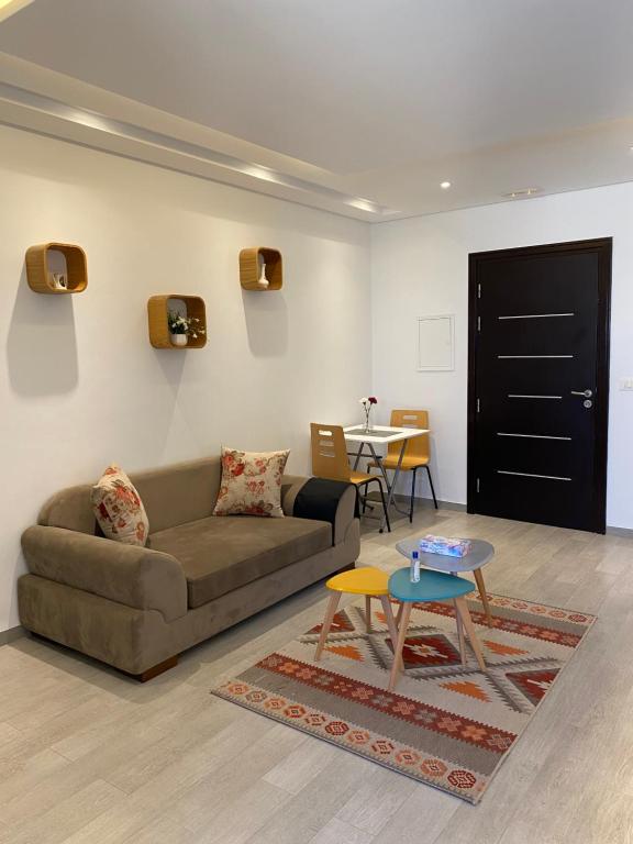 - un salon avec un canapé et une table dans l'établissement Residence haouari, à Sousse