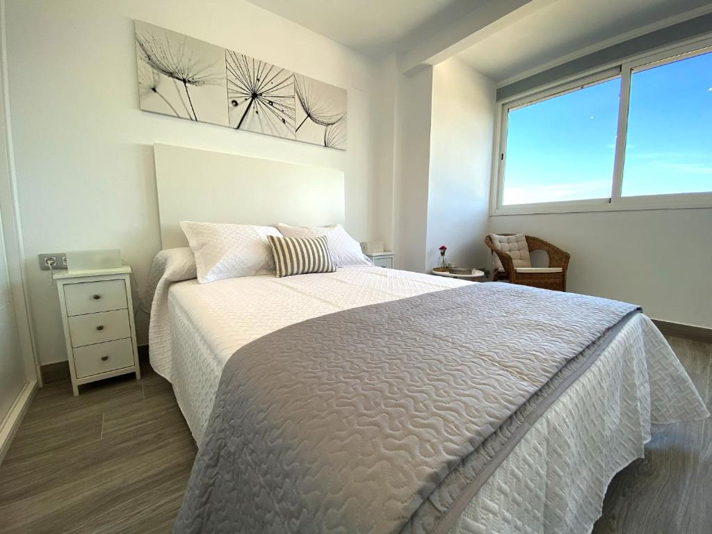ein Schlafzimmer mit einem großen Bett und einem Fenster in der Unterkunft Residencial Santa Justa - Vacacional Sevilla in Sevilla
