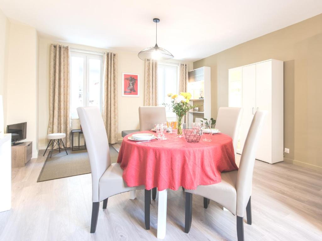 a dining room with a red table and white chairs at Charme au cœur d'avignon in Avignon