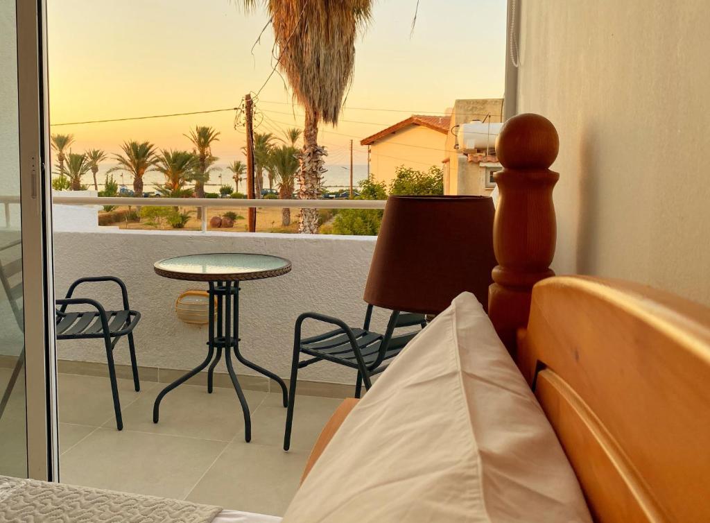 una camera da letto con balcone arredato con tavolo e sedie di JustSmile - Seaview Maisonette in Latchi a Lachi